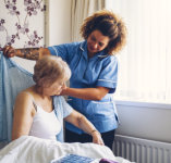 caregiver helping an elderly woman